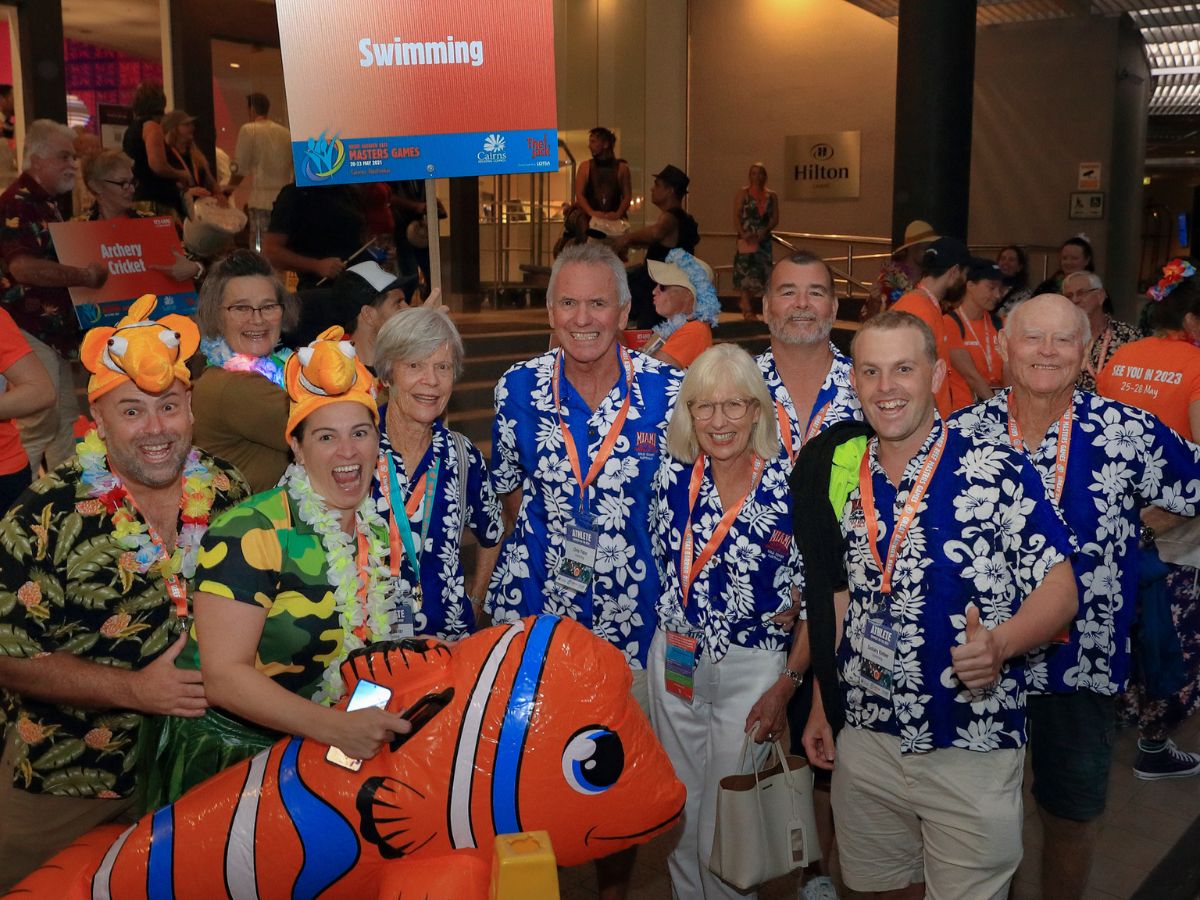 A group competitors smiling and posing for a photo at an event wearing tropical costumes