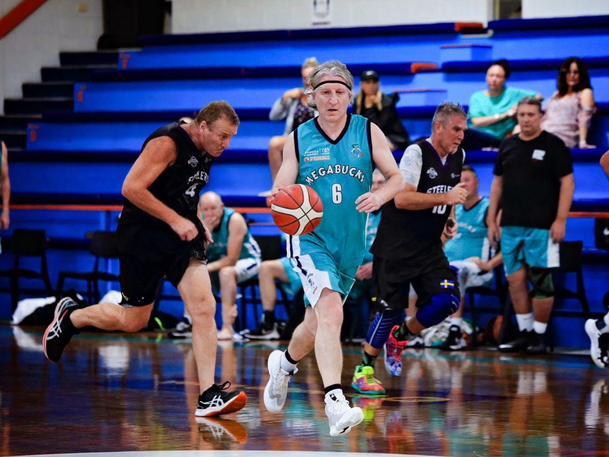 Masters dribbling basketball down the court