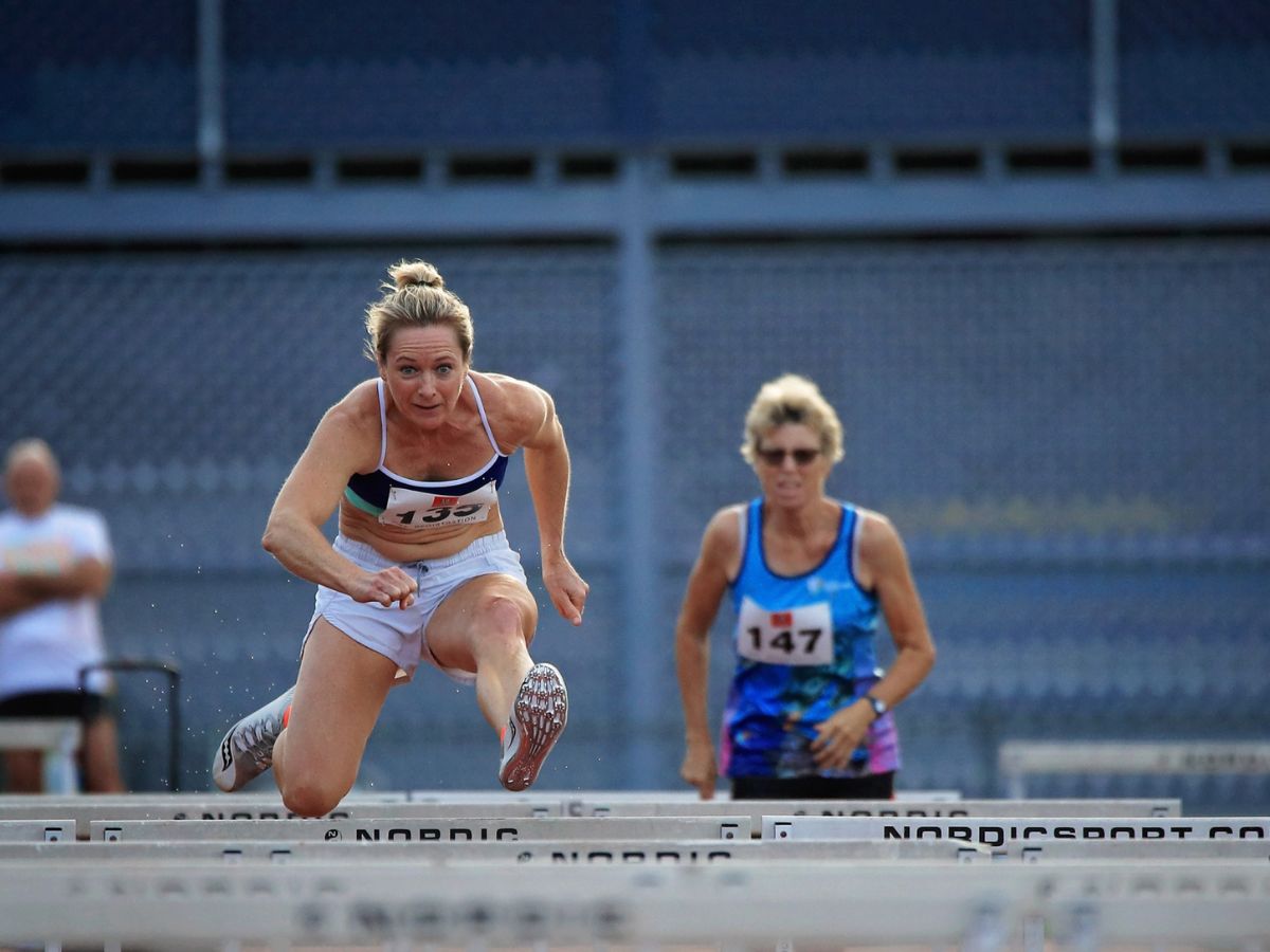 Masters competitor jumping hurdles