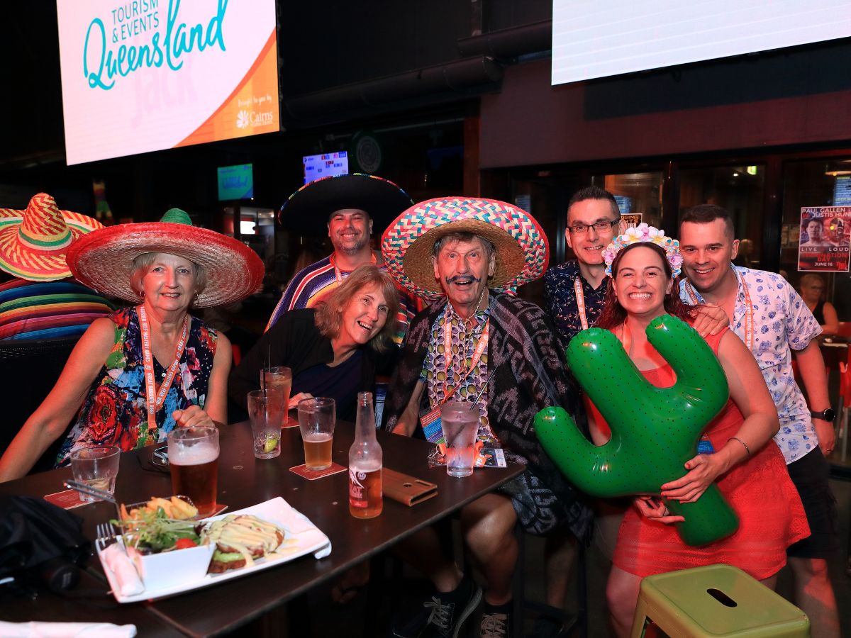 Group of people dressed in Mexican costumes posing for a photo at an event 