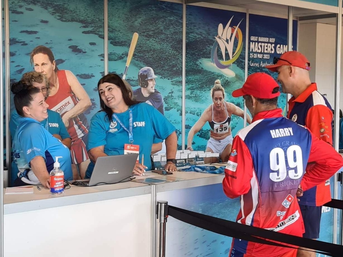 Two female volunteers assisting competitors with check in at the registration hub